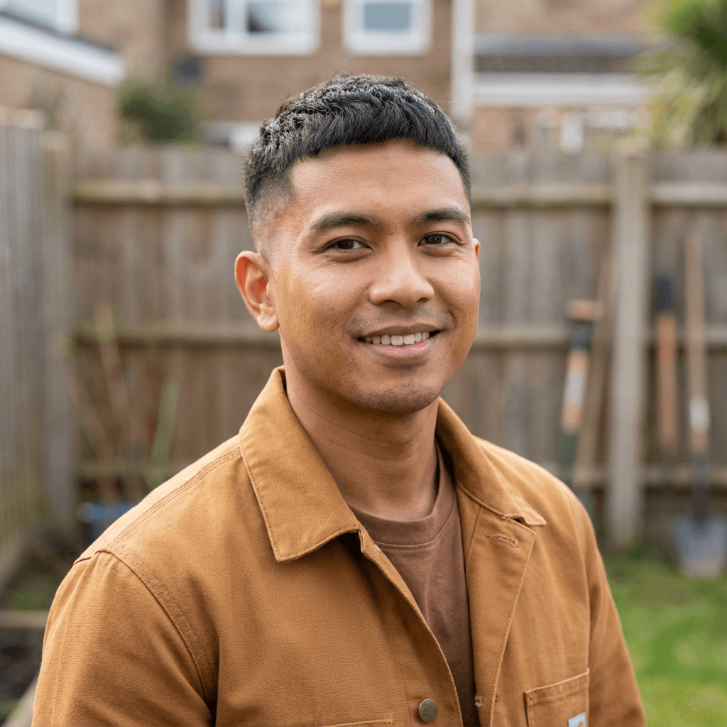 James R. in his 40s, Black, smiling with relief outside a house